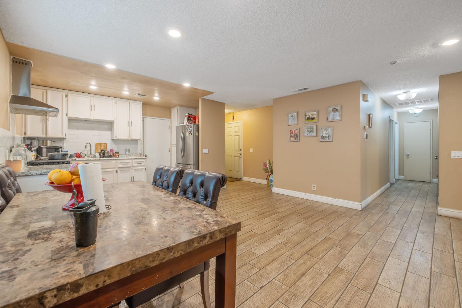 105 West Clark Street Madera, CA 93638 - Photo 11 of 33 a kitchen with stainless steel appliances granite countertop a sink refrigerator and cabinets