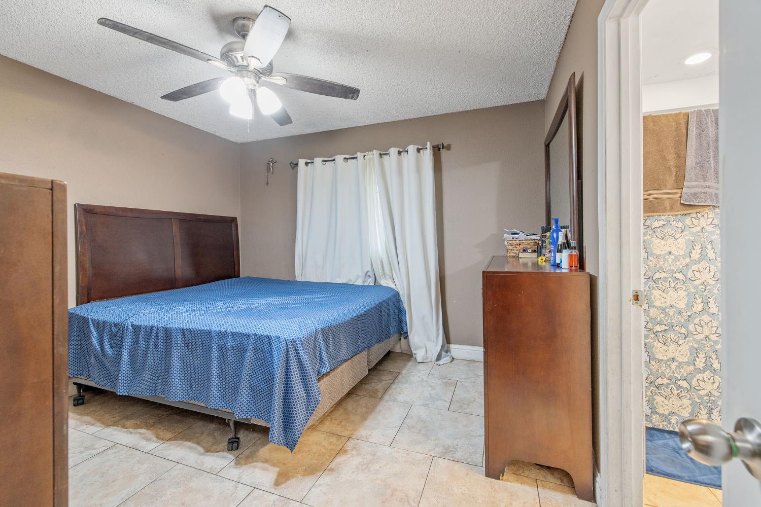 105 West Clark Street Madera, CA 93638 - Photo 25 of 33 a bedroom with a large bed and a chandelier