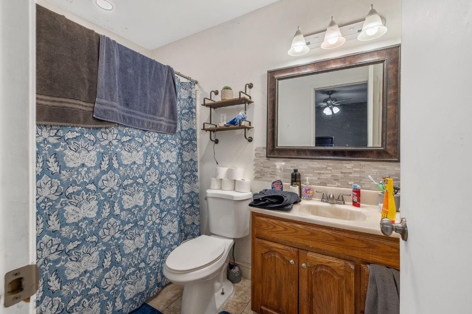 105 West Clark Street Madera, CA 93638 - Photo 27 of 33 a bathroom with a toilet sink vanity and mirror