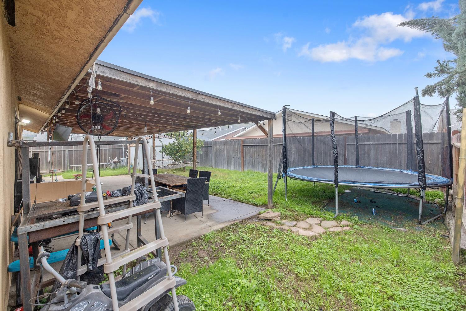 105 West Clark Street Madera, CA 93638 - Photo 28 of 33 a view of a chairs and table in backyard