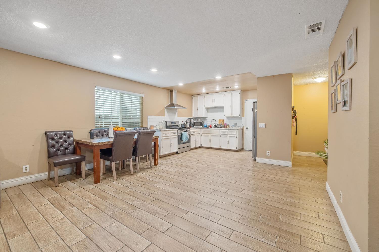 105 West Clark Street Madera, CA 93638 - Photo 9 of 33 a view of kitchen with kitchen island dining table and chairs