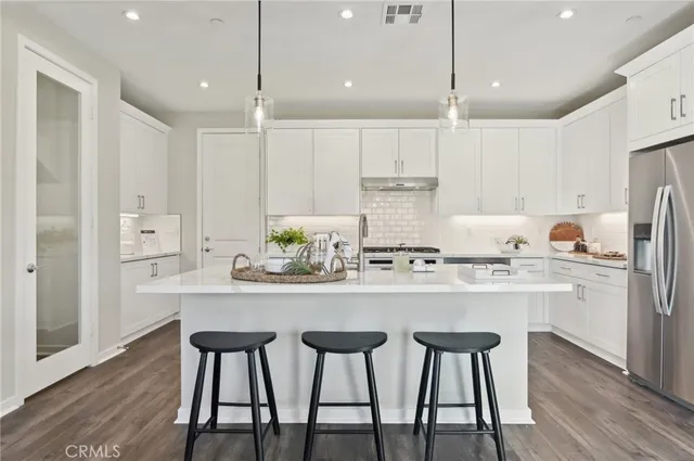 a kitchen with granite countertop white cabinets and stainless steel appliances