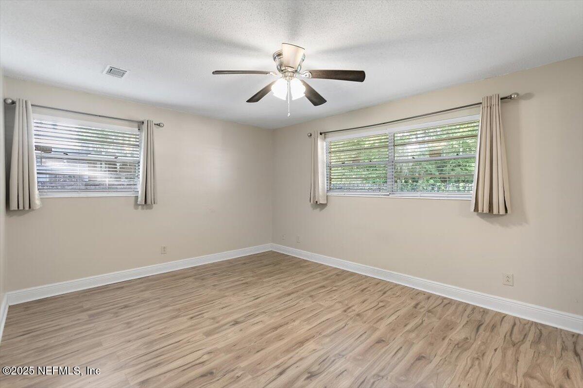 8408 Brierwood Road Jacksonville, FL 32217 - Photo 11 of 25 a view of an empty room with wooden floor and a window