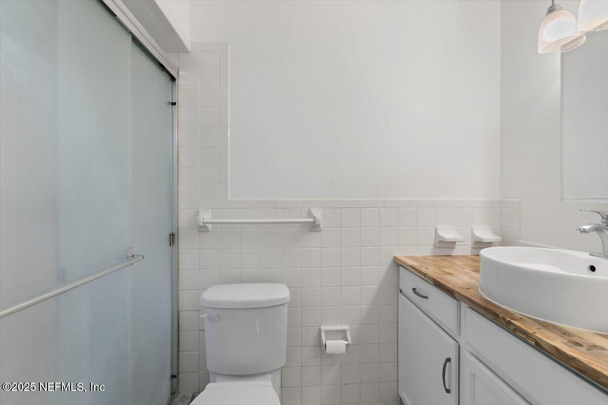 8408 Brierwood Road Jacksonville, FL 32217 - Photo 13 of 25 a bathroom with a granite countertop sink a toilet and a mirror