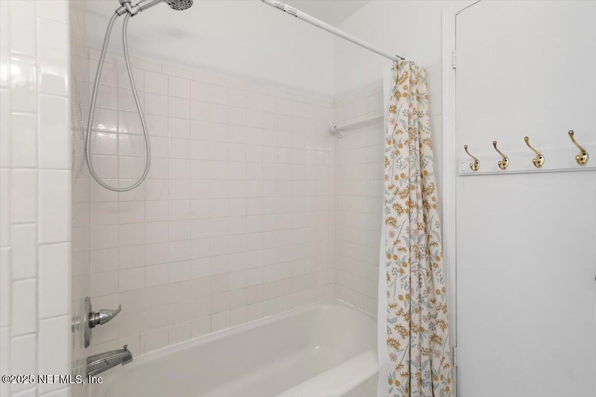 8408 Brierwood Road Jacksonville, FL 32217 - Photo 16 of 25 a bathroom with a shower curtain and a shower curtain