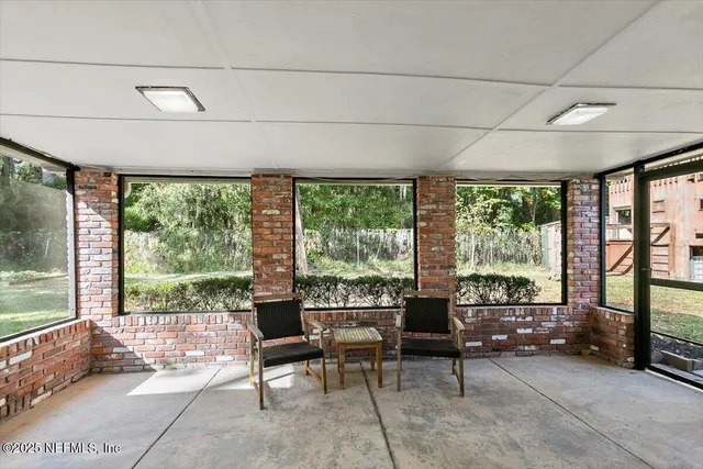 a living room with furniture and a floor to ceiling window
