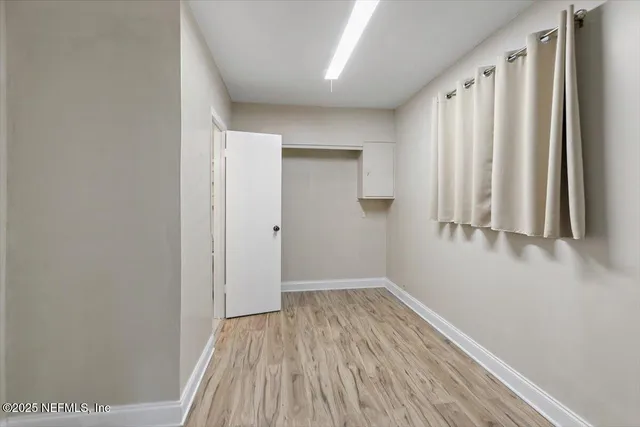 a view of a room with wooden floor and bench