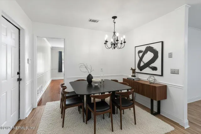 a view of a dining room with furniture and chandelier