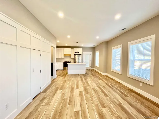 a view of a bedroom with wooden floor and windows