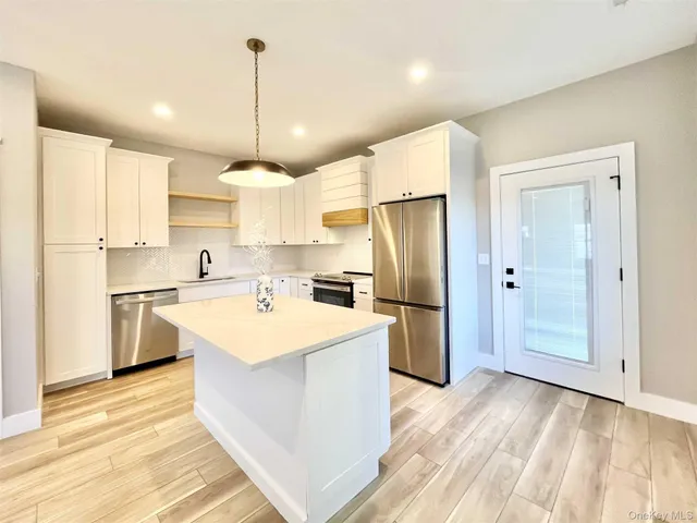 a kitchen with a refrigerator a sink dishwasher with a dining table and chairs