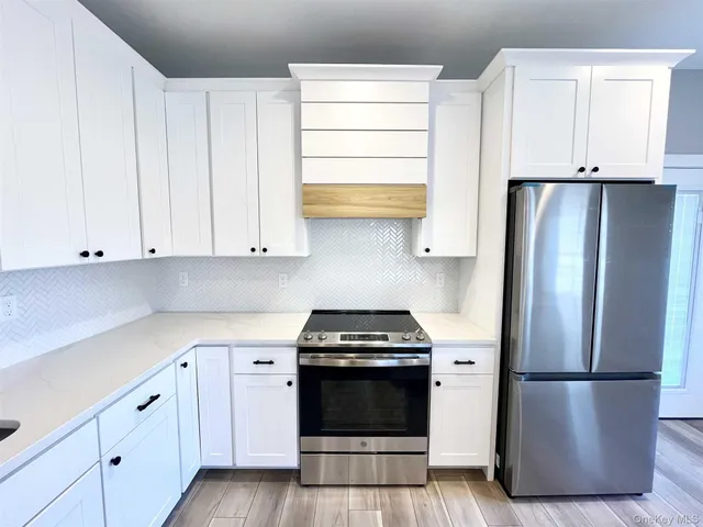 a kitchen with a refrigerator stove and white cabinets