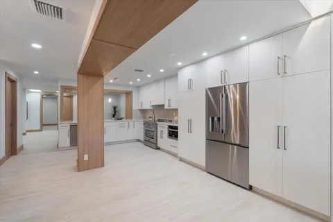a kitchen with white cabinets and white appliances