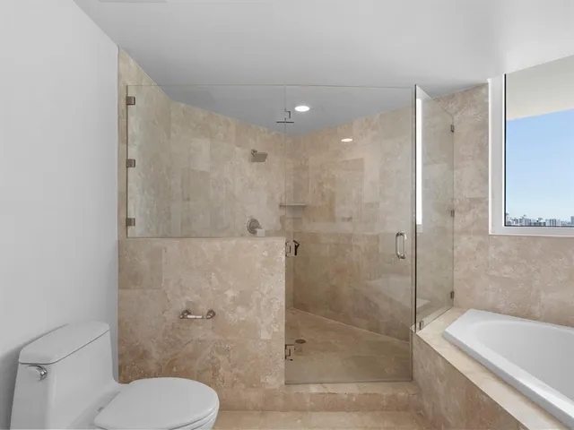 a bathroom with a granite countertop bathtub sink and mirror