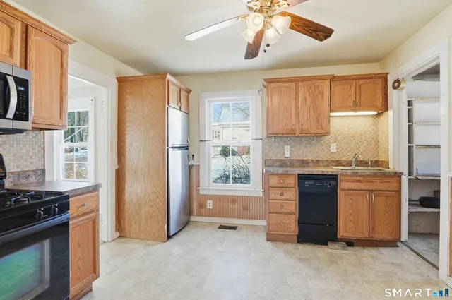 a kitchen with stainless steel appliances granite countertop a refrigerator and a stove top oven