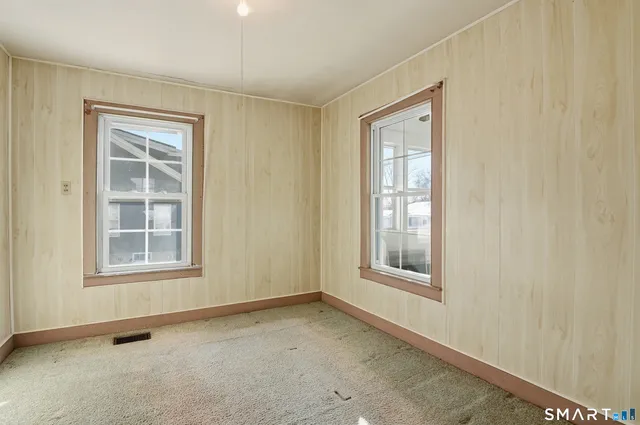a view of an empty room with window and stairs