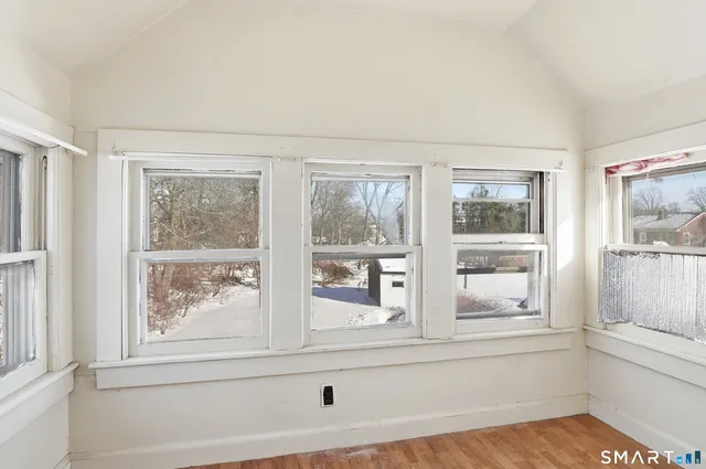 a view of an empty room with wooden floor