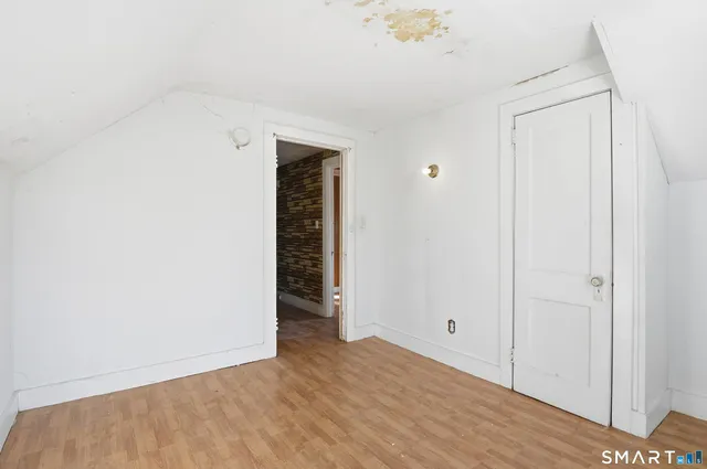 a view of a room with wooden floor and entryway