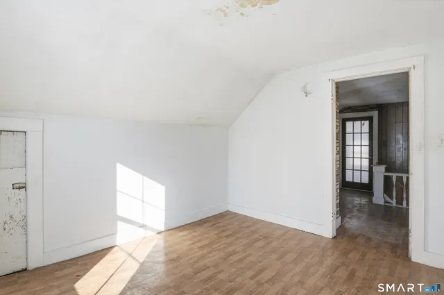 a view of a hallway with wooden floor and staircase