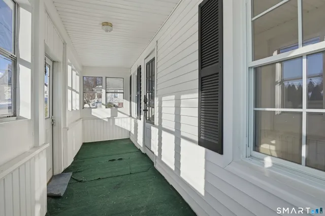 a view of a hallway with wooden floor and windows
