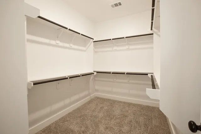 a view of walk in closet with empty racks