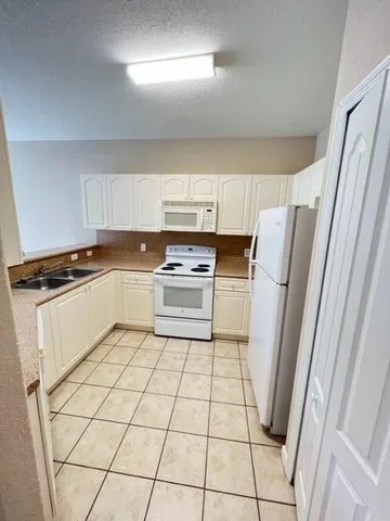 a kitchen with cabinets and white appliances