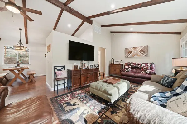 a living room with furniture a table and a large window