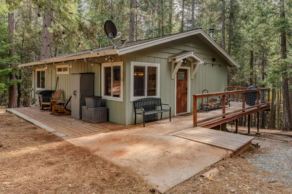 a view of a house with wooden deck and furniture
