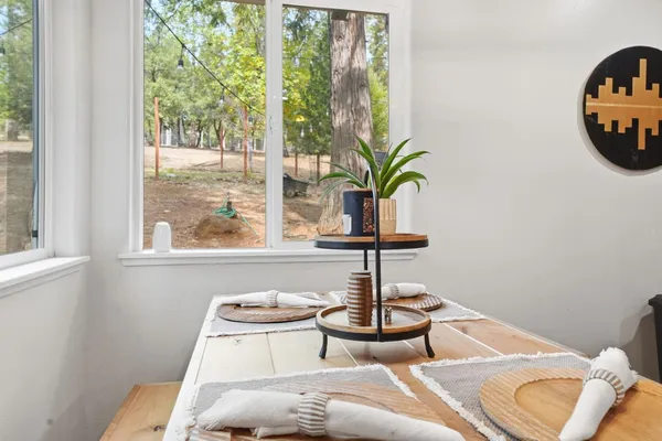a kitchen with stainless steel appliances granite countertop a dining table and chairs in it