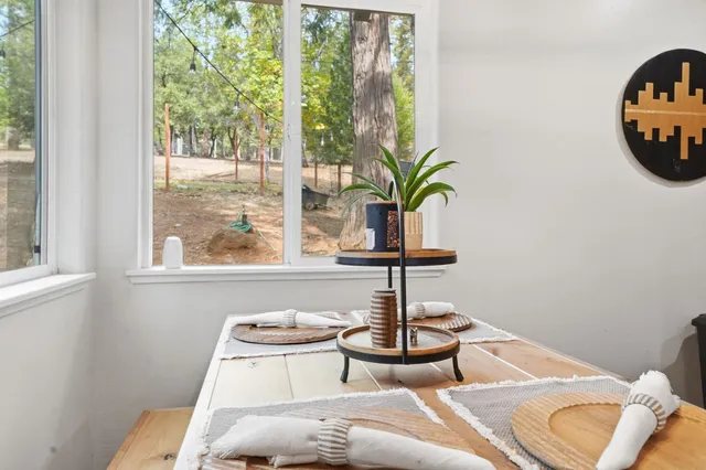 a kitchen with stainless steel appliances granite countertop a dining table and chairs in it