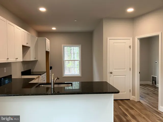 a kitchen with granite countertop a sink a stove and a refrigerator