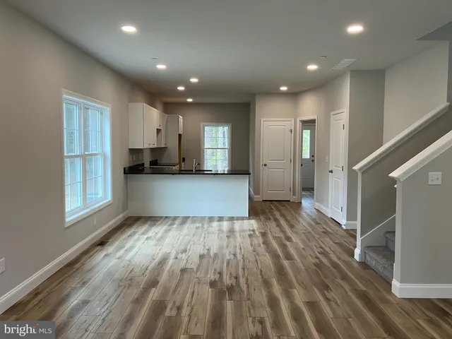 a view of a kitchen cabinets wooden floor and staircase