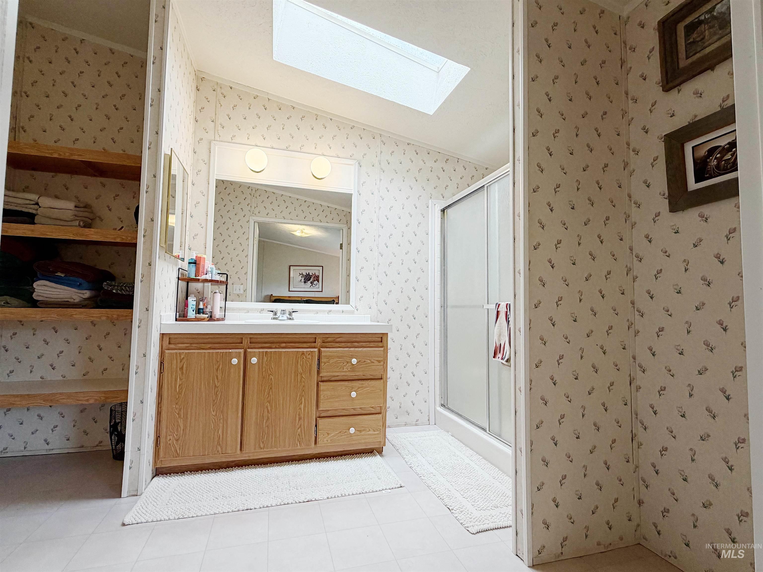 2605 West Frk Road Council, ID 83612 - Photo 26 of 34 Bathroom with vanity, a stall shower, a skylight, and wallpapered walls