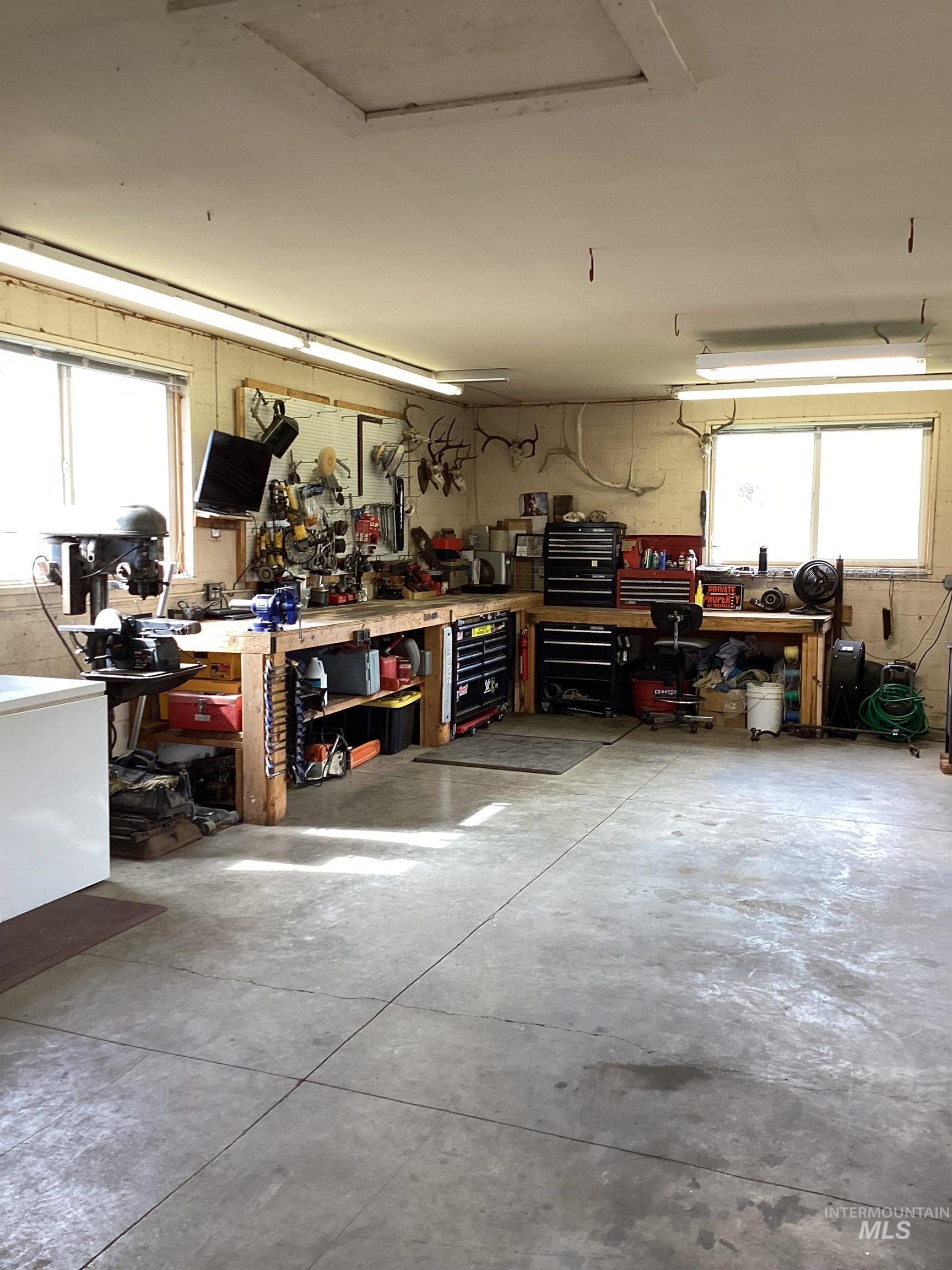 2605 West Frk Road Council, ID 83612 - Photo 32 of 34 Garage with white fridge and a workshop area