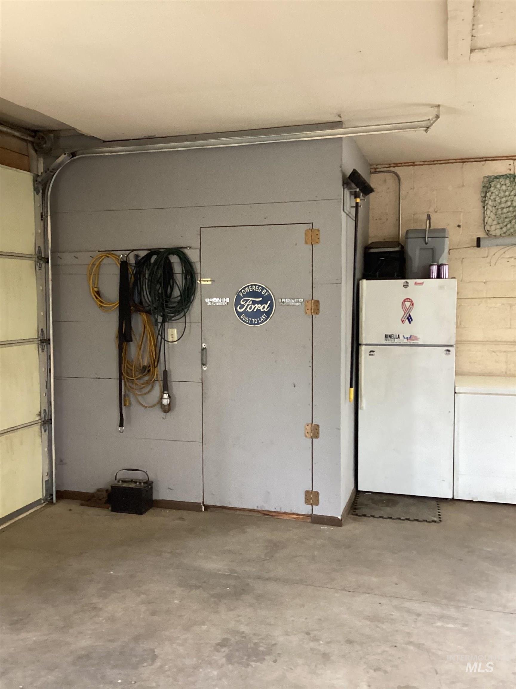 2605 West Frk Road Council, ID 83612 - Photo 34 of 34 Garage with freestanding refrigerator, concrete block wall, and white fridge
