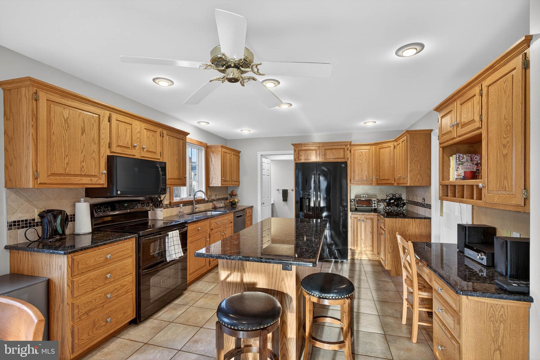 35 Old Post Lane Lititz, PA 17543 - Photo 4 of 61 a kitchen with stainless steel appliances granite countertop a stove top oven a sink a dining table and chairs with wooden floor