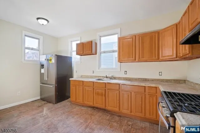 a kitchen with stainless steel appliances granite countertop a refrigerator sink and stove