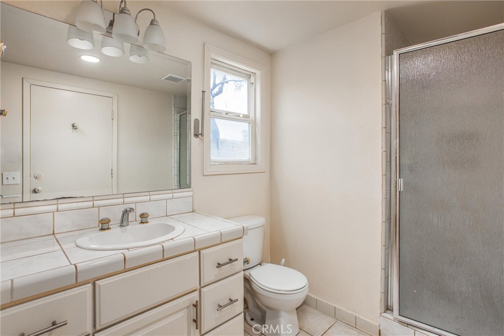 6966 Ranch View Road Riverside, CA 92506 - Photo 51 of 73 a bathroom with a sink toilet a mirror and vanity