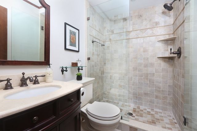 a bathroom with a sink a toilet and shower