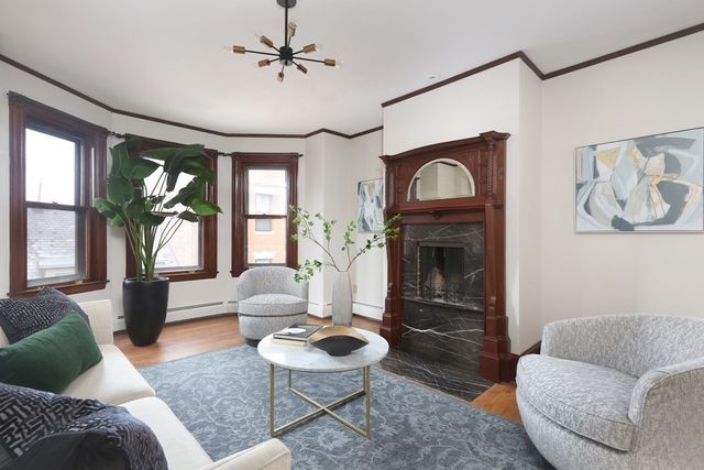 a living room with furniture a fireplace and a large window