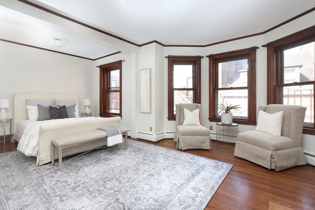 a spacious bedroom with a bed couch and windows