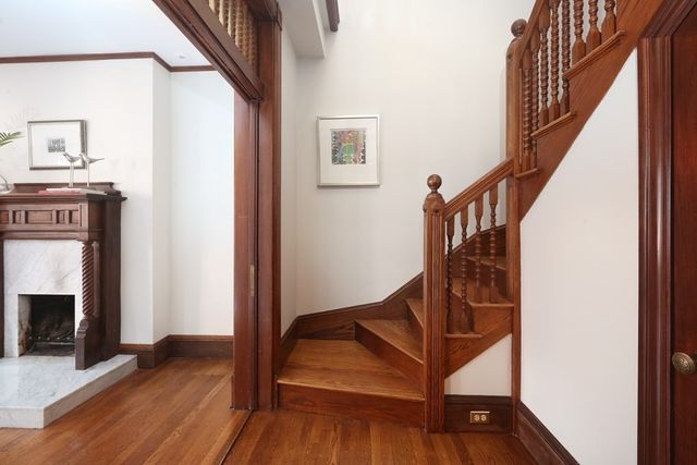 a view of entryway with wooden floor and a fireplace