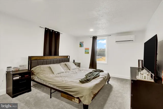 a bedroom with a bed and a flat screen tv