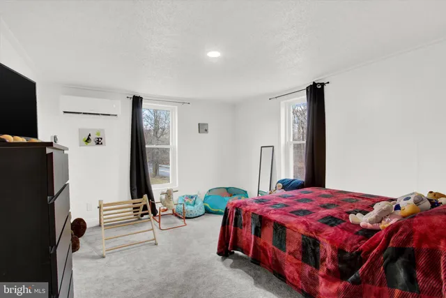 a bedroom with a bed a flat screen tv and a dresser