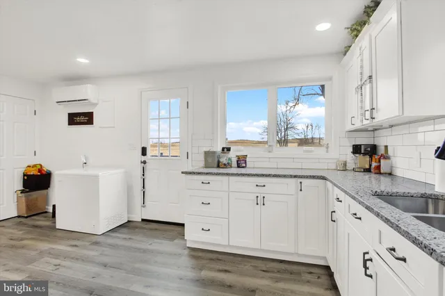 a kitchen with granite countertop white cabinets and white appliances