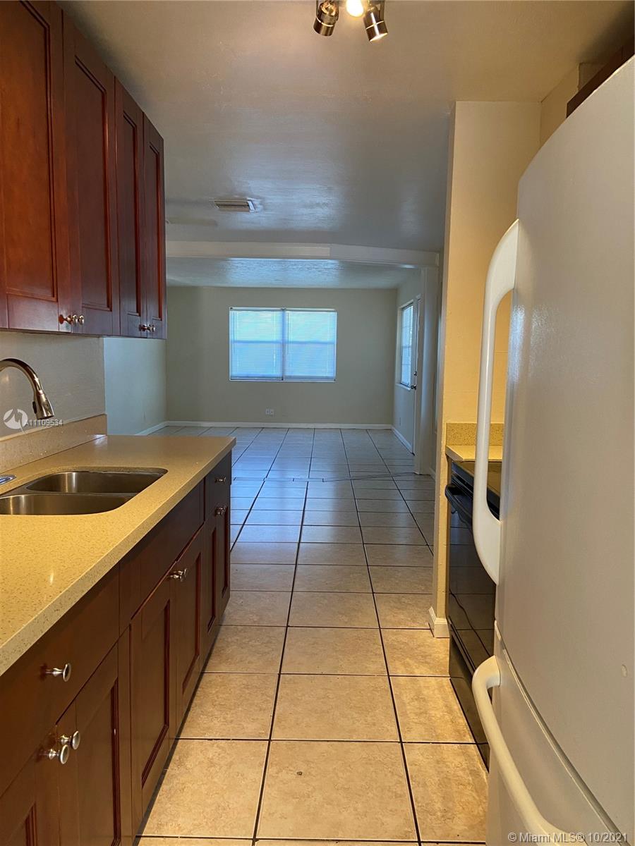 1509 Pine Tree Court Riviera Beach, FL 33404 - Photo 11 of 19 a kitchen with a sink and cabinets