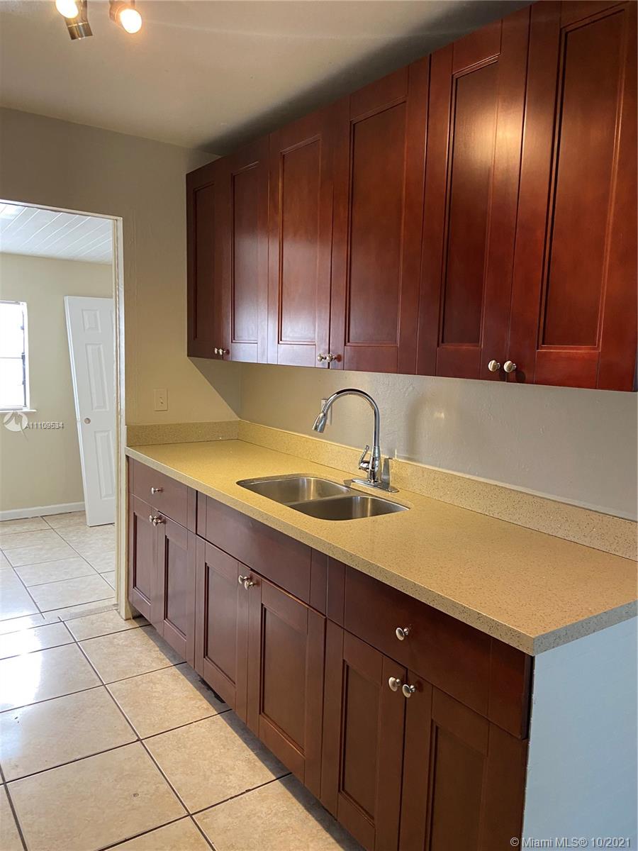 1509 Pine Tree Court Riviera Beach, FL 33404 - Photo 9 of 19 a kitchen with a sink and cabinets