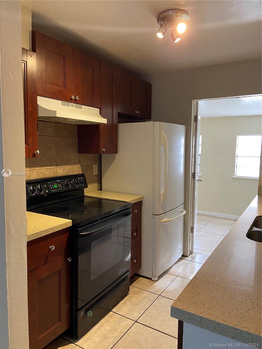 1509 Pine Tree Court Riviera Beach, FL 33404 - Photo 10 of 19 a kitchen with a refrigerator and a sink