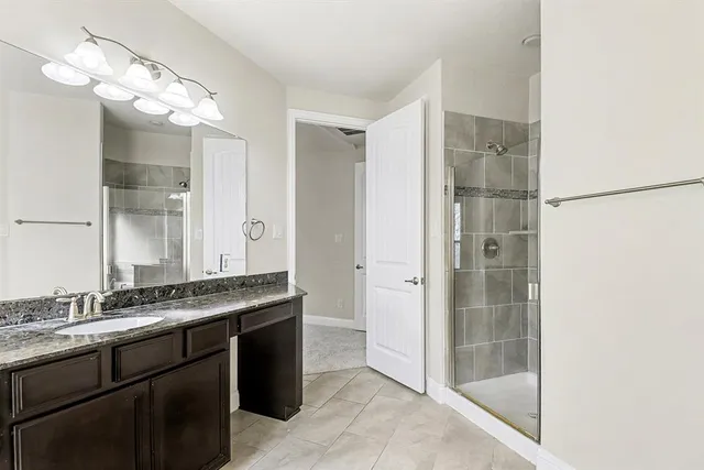a bathroom with a granite countertop sink shower and a mirror