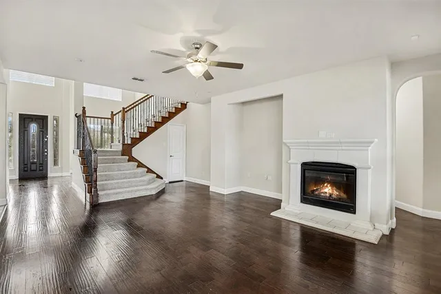 a view of a livingroom with wooden floor and a fireplace