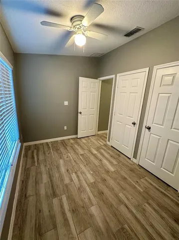 a view of empty room with wooden floor